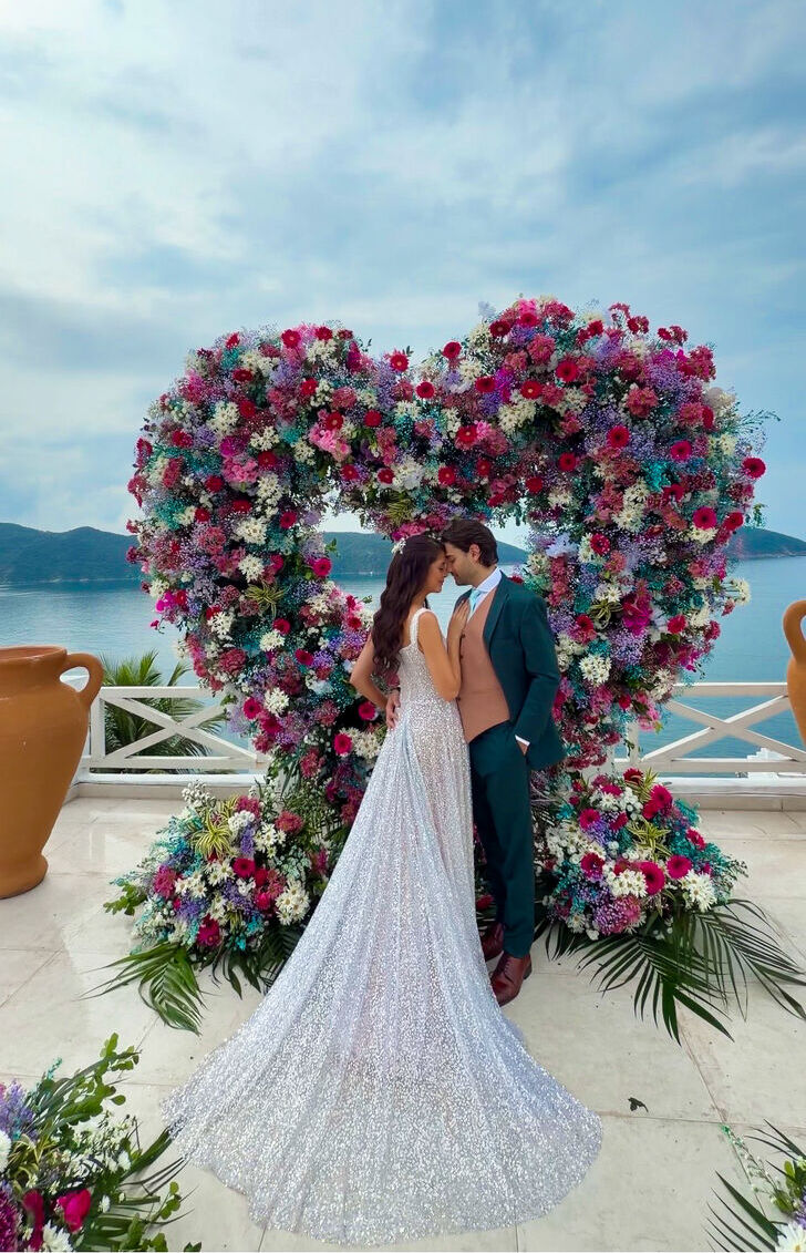 Felipe e Karolline sob o arco de flores